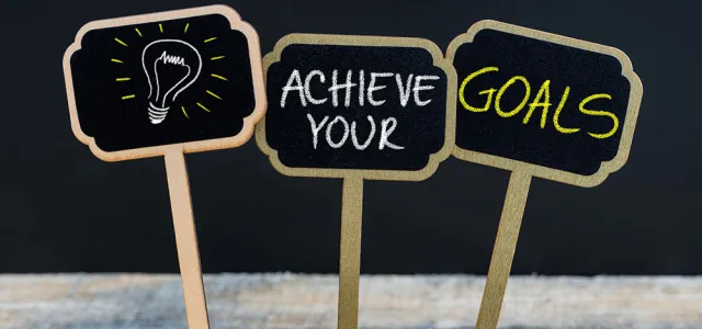 Concept message ACHIEVE YOUR GOALS and light bulb as symbol for idea